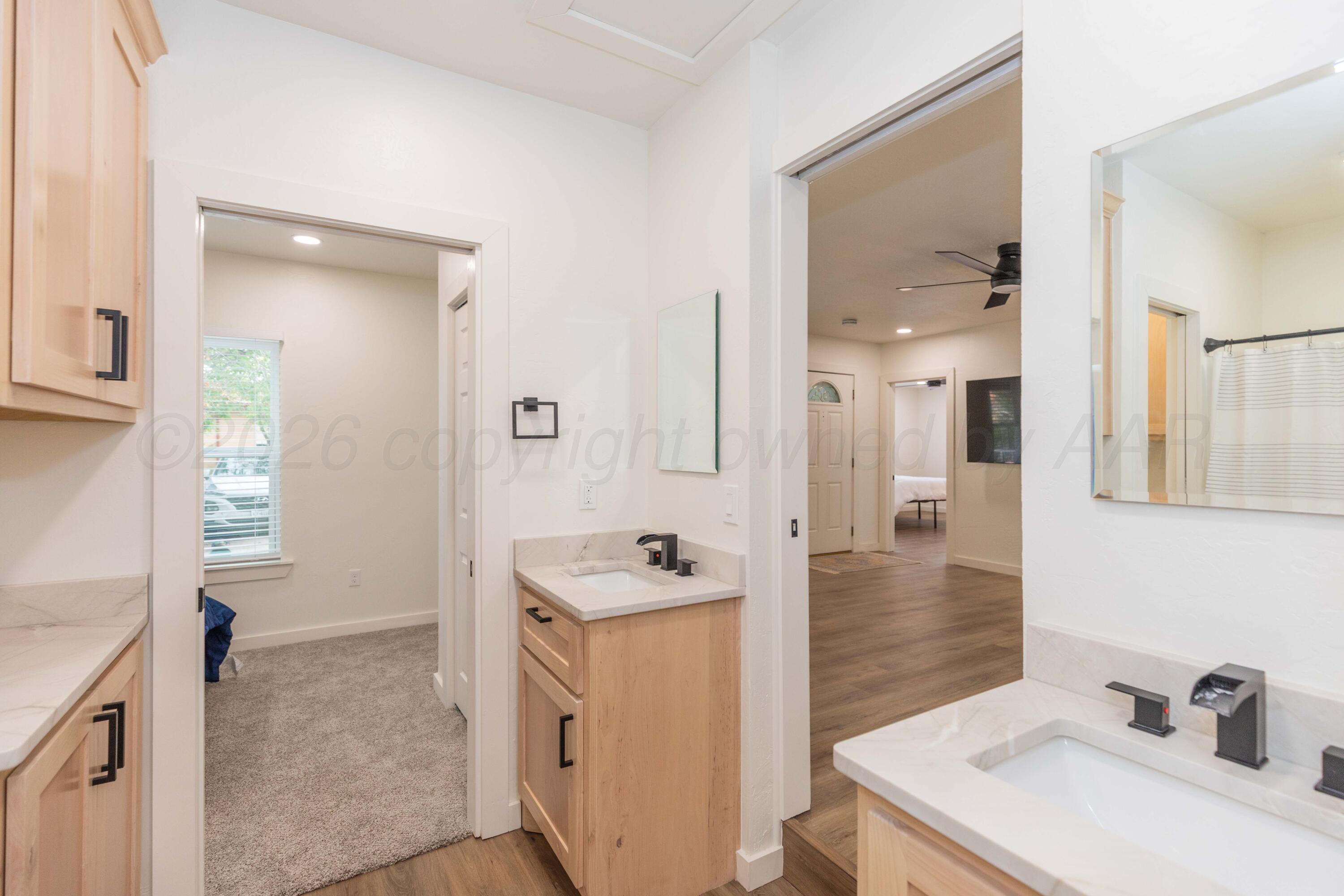 504 High Street Claude, TX 79019 - Photo 7 of 39 a bathroom with a sink a mirror and a shower