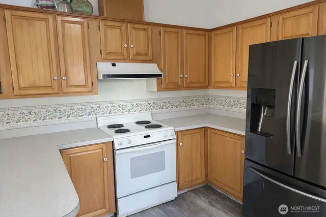 a kitchen with stainless steel appliances a refrigerator sink and cabinets