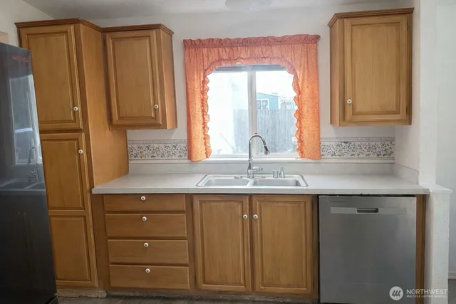 a kitchen with appliances a sink and cabinets