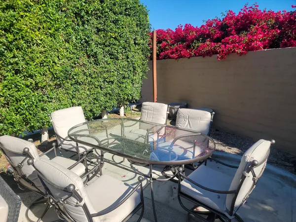 a view of a chairs and table in a backyard