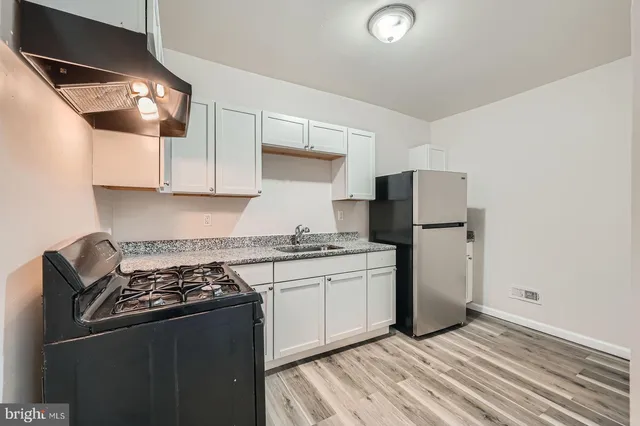 a white refrigerator freezer and a stove sitting inside of a kitchen