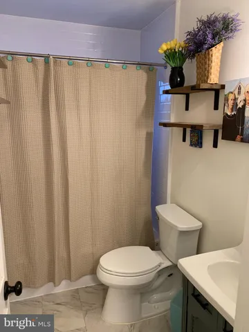 a view of a room with wooden floor and ceiling fan