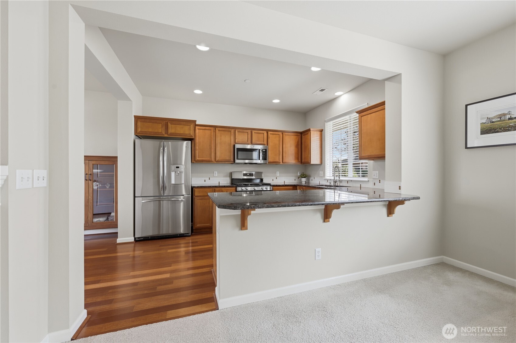 18635 101st Avenue Northeast, Unit 6 Bothell, WA 98011 - Photo 7 of 23 a kitchen with stainless steel appliances kitchen island granite countertop a refrigerator and a sink
