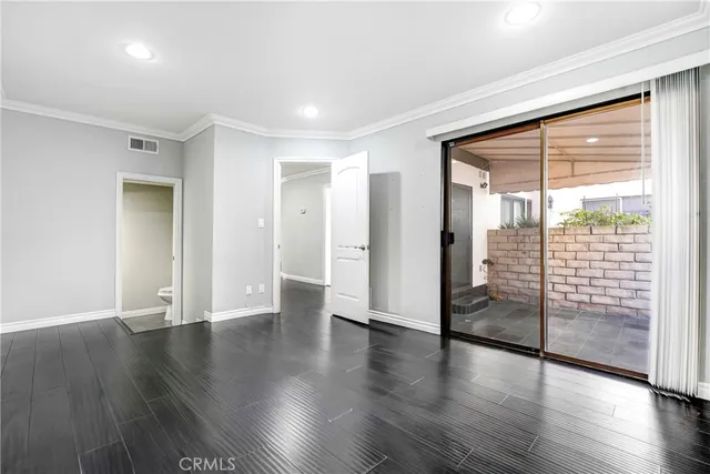 a view of a big room with wooden floor and windows