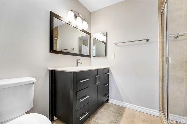 a bathroom with a sink vanity mirror and toilet