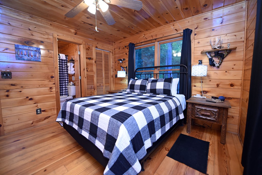 789 Old Mill Pond Road Mineral Bluff, GA 30559 - Photo 48 of 59 a bed sitting in a bedroom next to a lamp