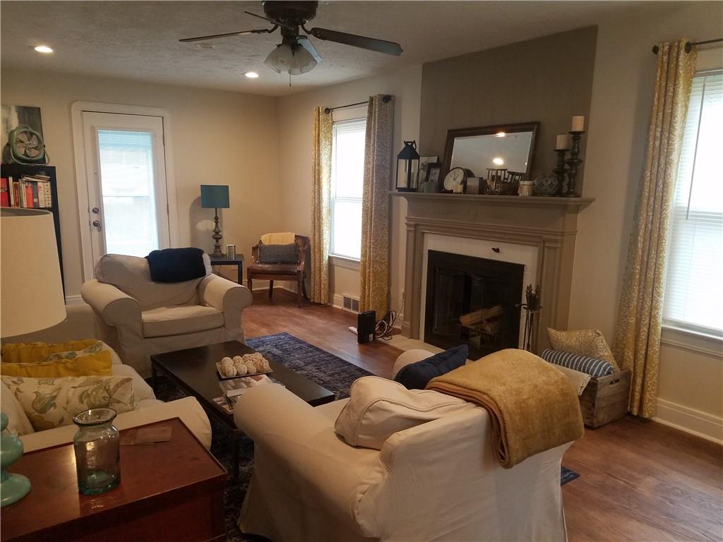 Spacious living room with wood burning fireplace, new recessed lighting, refinished hardwood flooring. 