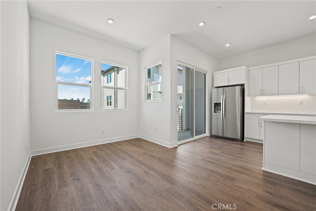 1822 West Bushell Street Anaheim, CA 92805 - Photo 18 of 34 a view of an empty room with wooden floor and a kitchen