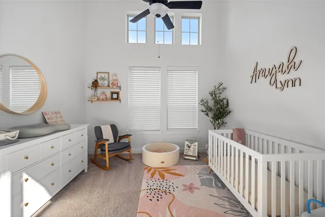 a bedroom with a baby bed a couch and a potted plant