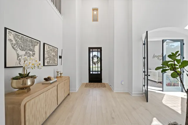 a hallway with painting on the wall and a potted plant