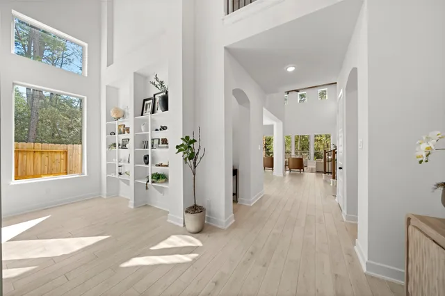 a view of a hallway with wooden floor and a living room