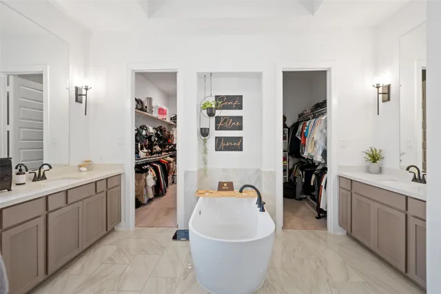 a large bathroom with a granite countertop sink a mirror a bathtub and shower