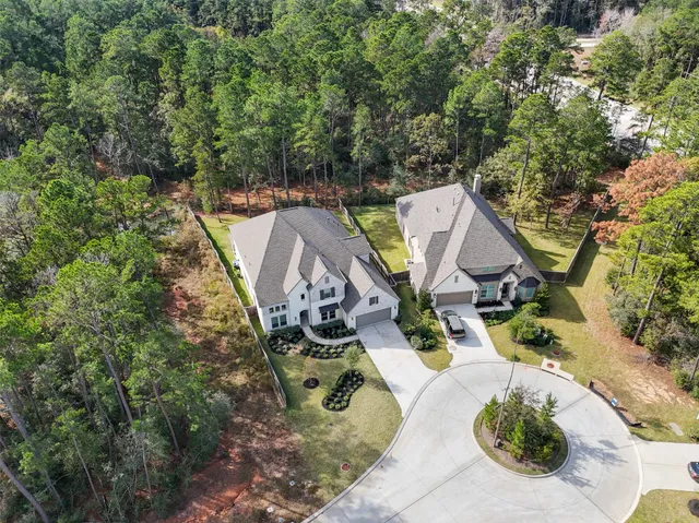 an aerial view of a house with a yard and large trees