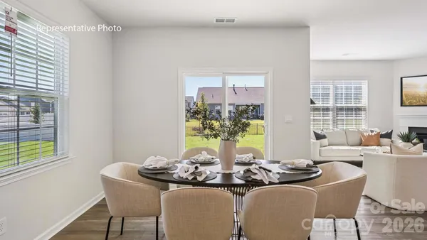 a dining room with furniture and a potted plant