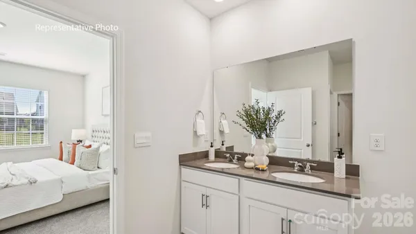 a bath room with a double vanity sink and a mirror
