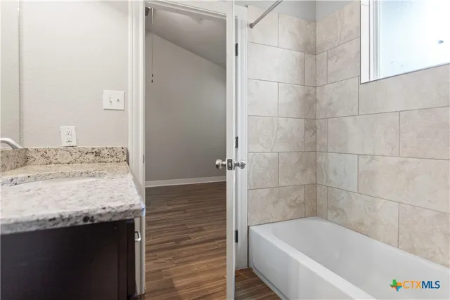 a bathroom with a granite countertop bathtub and shower