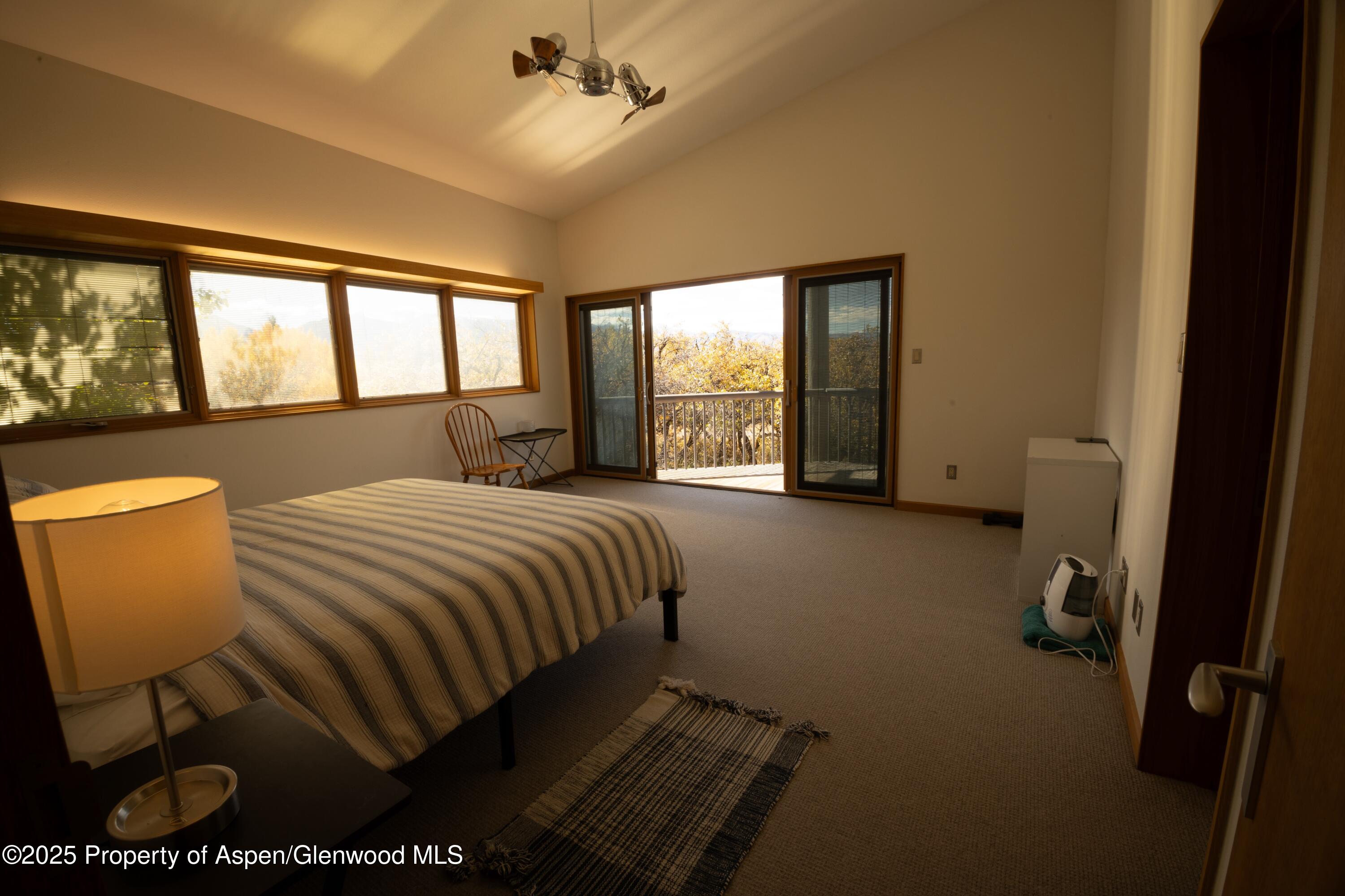 623 Johnson Drive Aspen, CO 81612 - Photo 19 of 35 a bedroom with a bed and a chair with the outer view