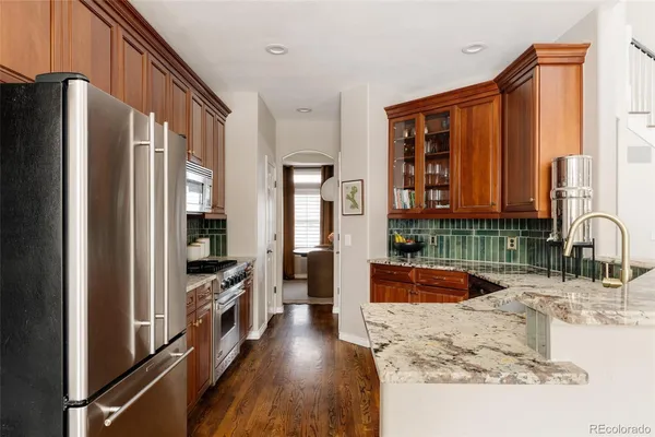 a kitchen with stainless steel appliances granite countertop a refrigerator and a sink