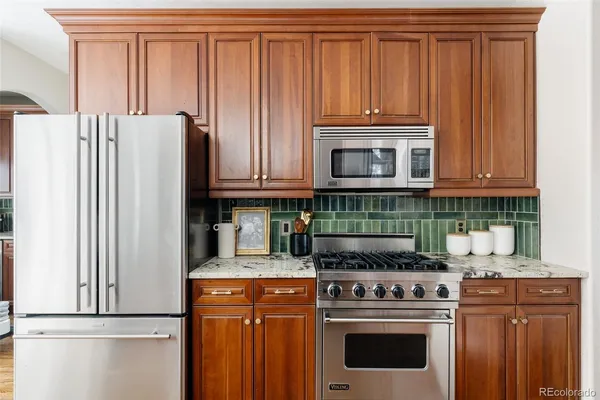 a kitchen with granite countertop a stove top oven and cabinets