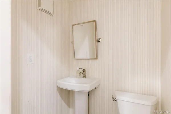 a bathroom with a sink a toilet and mirror