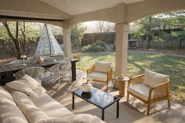 a view of a patio with couches chairs and a floor to ceiling window