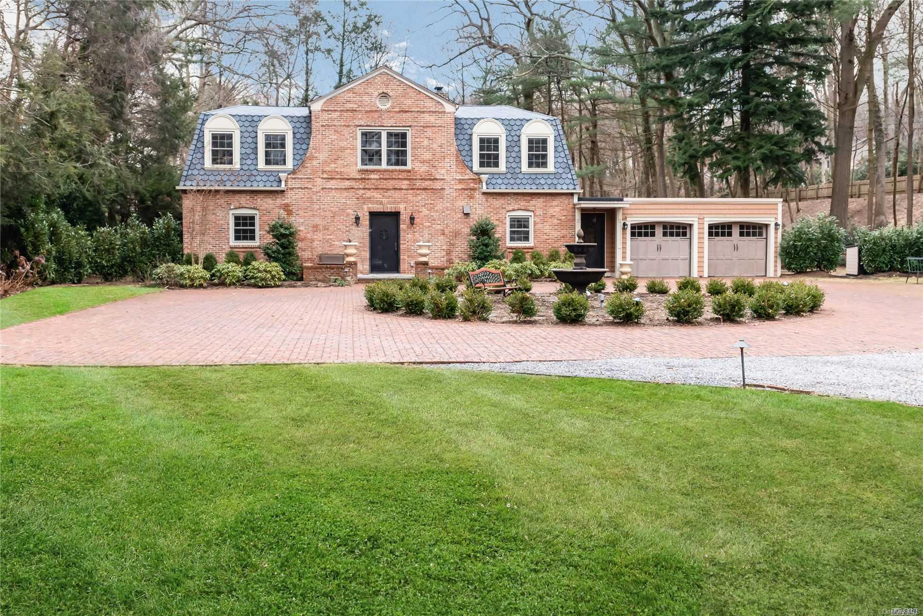 a front view of a house with a garden and yard
