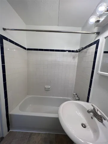 a bathroom with a sink a toilet a mirror and shower
