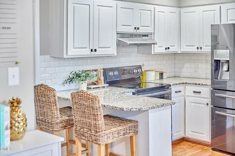 a kitchen with granite countertop a stove a sink and a counter space