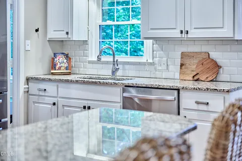 a kitchen with stainless steel appliances granite countertop kitchen island wooden cabinets and refrigerator