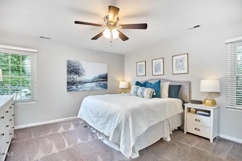 a spacious bedroom with a large bed and a chandelier