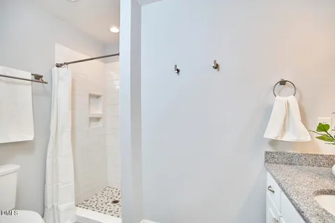 a bathroom with a granite countertop bathtub shower sink and mirror