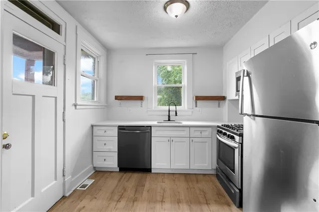 a kitchen with a refrigerator stove and sink