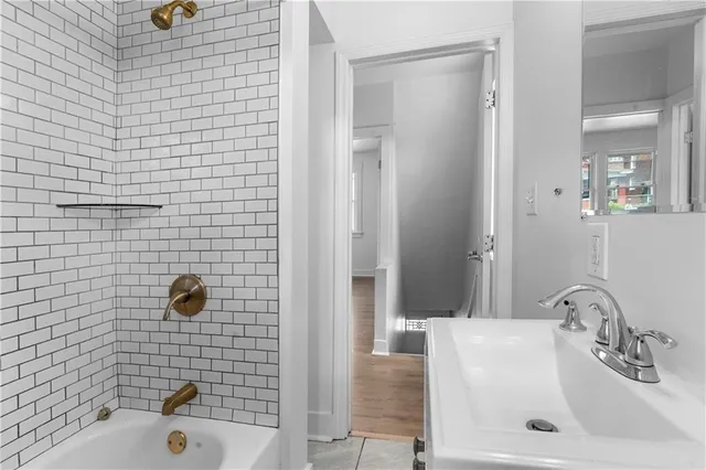 a bathroom with a tub a sink and mirror