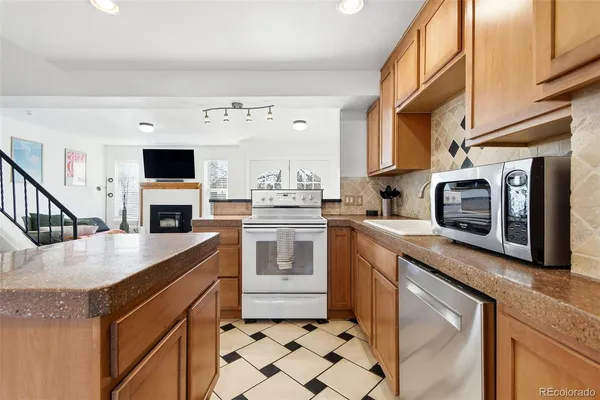a kitchen with stainless steel appliances granite countertop a stove a sink and a microwave