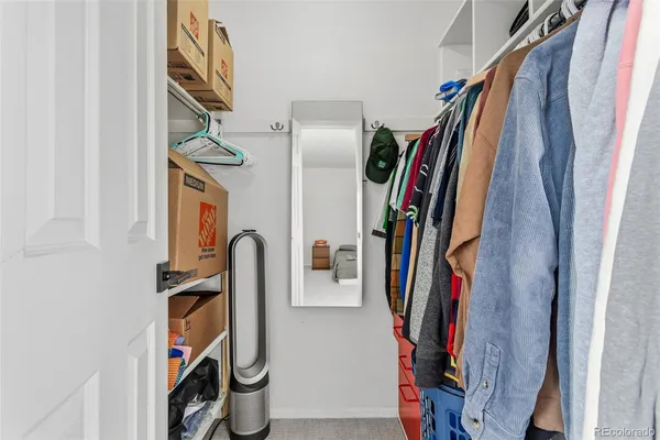 a view of walk in closet with clothes and shoes