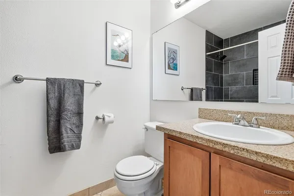 a bathroom with a granite countertop sink toilet and shower