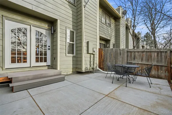 a view of a patio with table and chairs and wooden fence