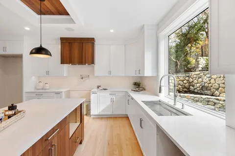 a kitchen with a sink a stove and cabinets
