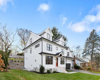 a view of a white house with a big yard and large trees