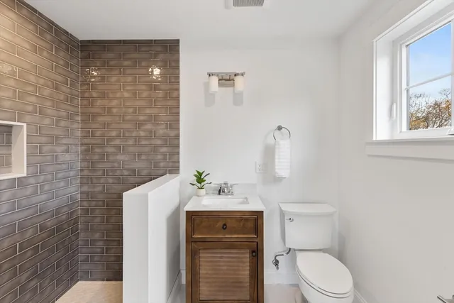 a bathroom with a toilet sink and mirror