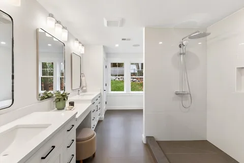 a bathroom with a double vanity sink a mirror a bathtub and shower