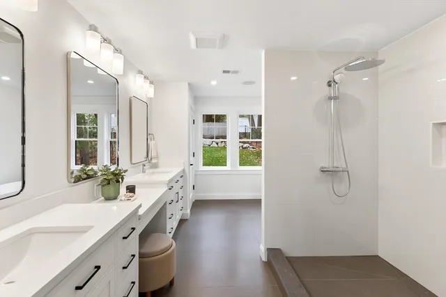 a bathroom with a double vanity sink a mirror a bathtub and shower