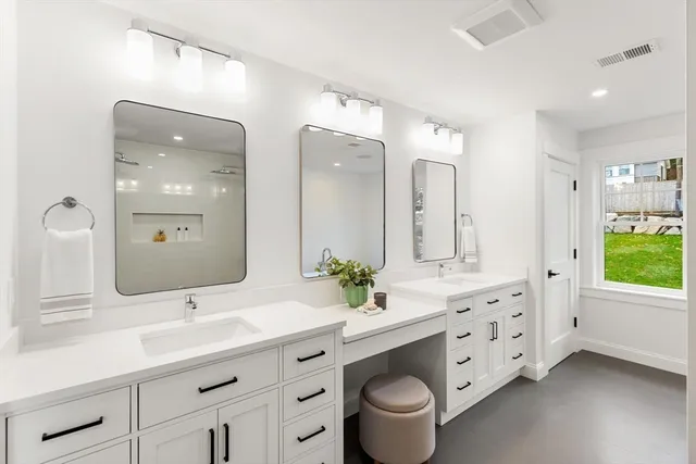 a bathroom with a double vanity sink mirror and toilet