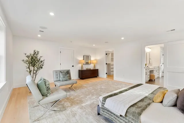 a spacious bedroom with a large bed and a chandelier