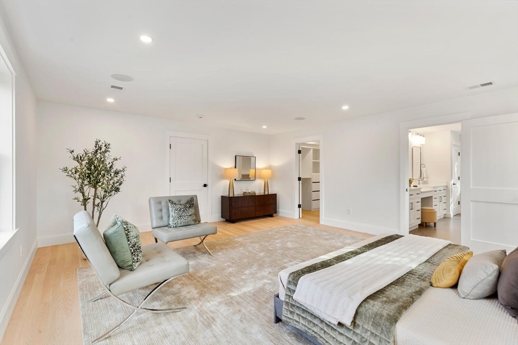 19 Town Way Winchester, MA 01890 - Photo 30 of 42 a spacious bedroom with a large bed and a chandelier