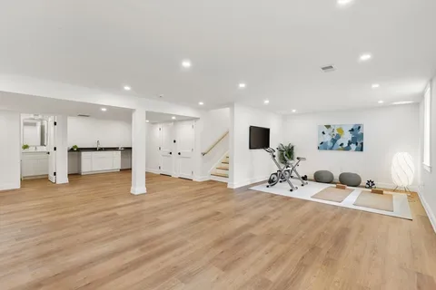 a large bedroom with a bed and a view of kitchen