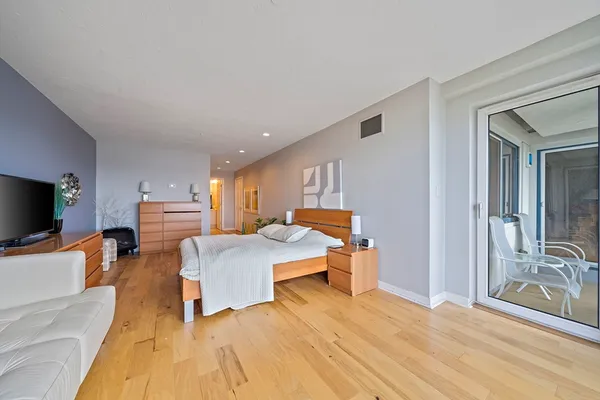 a bedroom with a bed and a flat tv screen on the dresser