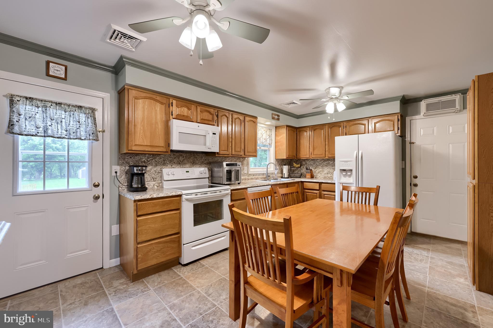 699 River Corner Road Conestoga, PA 17516 - Photo 8 of 37 a large kitchen with a table chairs refrigerator and cabinets