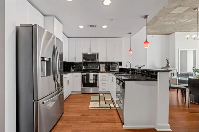a kitchen with stainless steel appliances granite countertop a stove and white cabinets