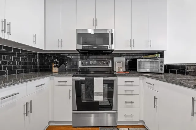 a kitchen with stainless steel appliances granite countertop a sink and a stove
